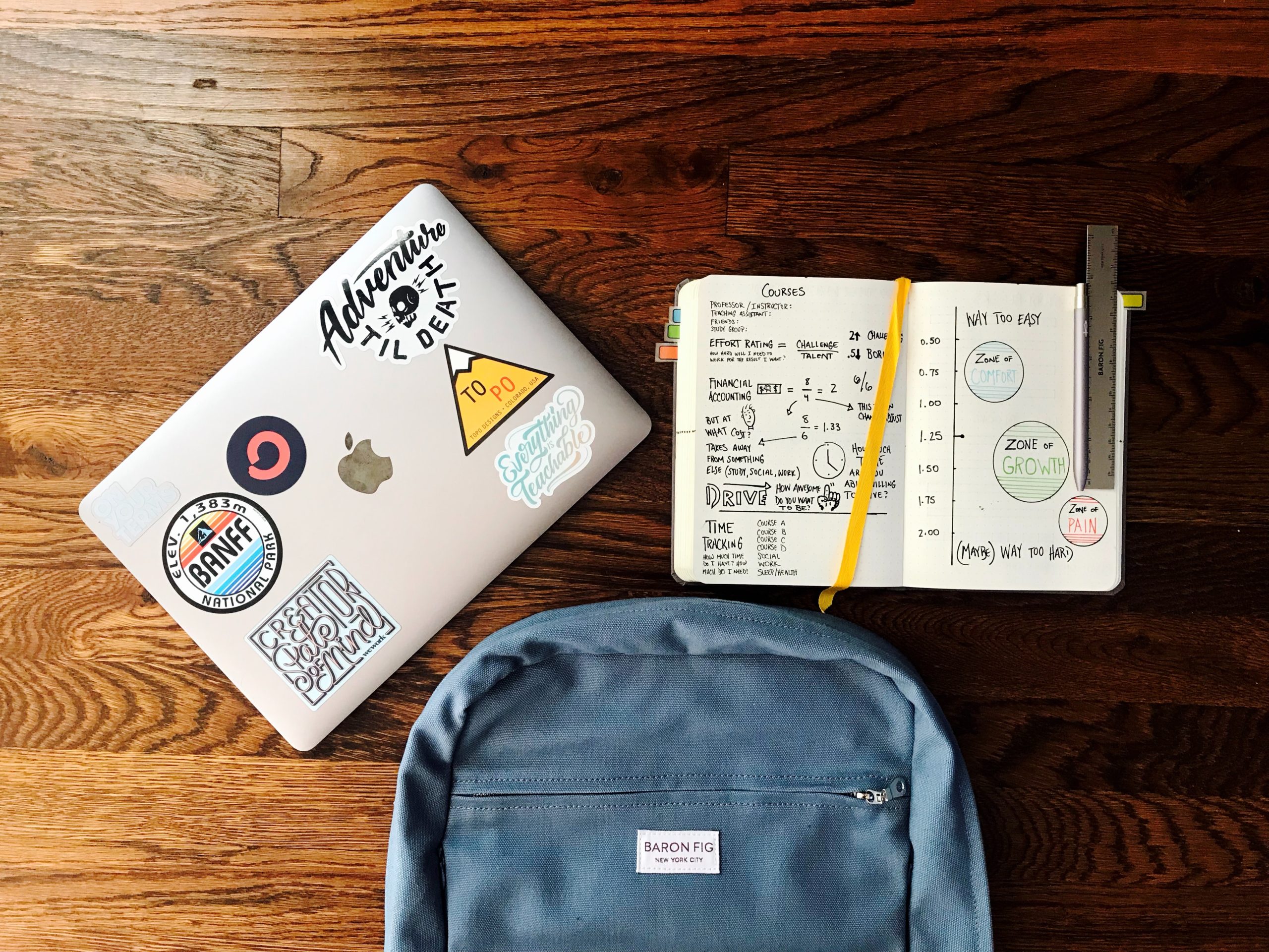 a laptop, bookbag, and notebook on a table